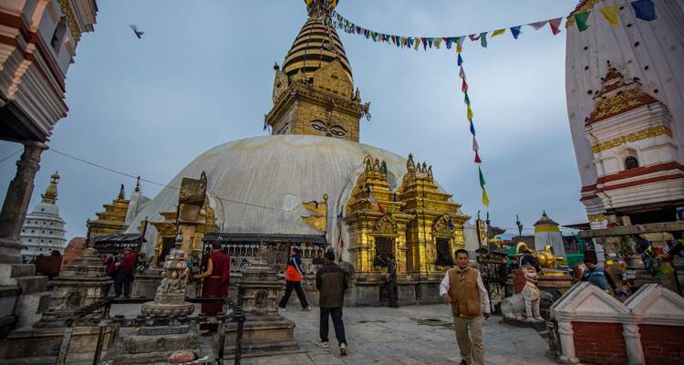Las torres doradas y los ojos omnividentes del estupa Swayambhunath con banderas de oración ondeando en lo alto.