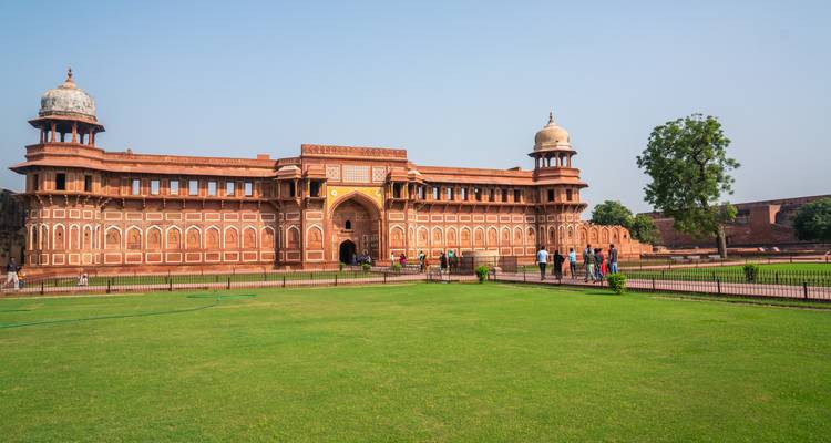 Large fort with sandstone walls and people exploring.