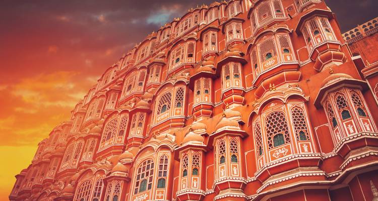 Ornate pink architecture at sunset with dramatic sky.