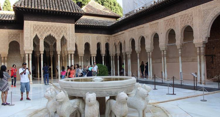 Innenhof mit einem Brunnen und Säulen, viele Besucher rundherum.