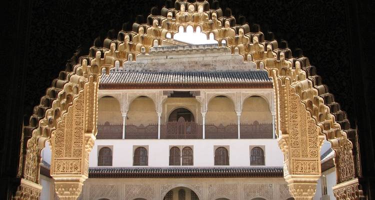 Kunstvoll detaillierter gewölbter Türbogen mit Blick auf einen historischen Palast.
