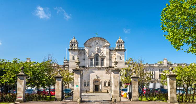 A grand historical building situated in a city square.