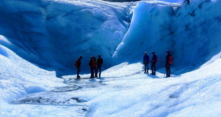 Group of hikers standing in a glacier canyon.