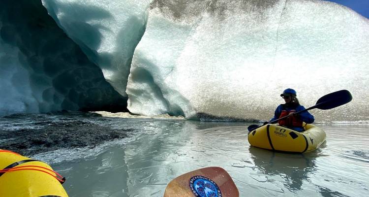 Kayaker navigating through glacier formations.