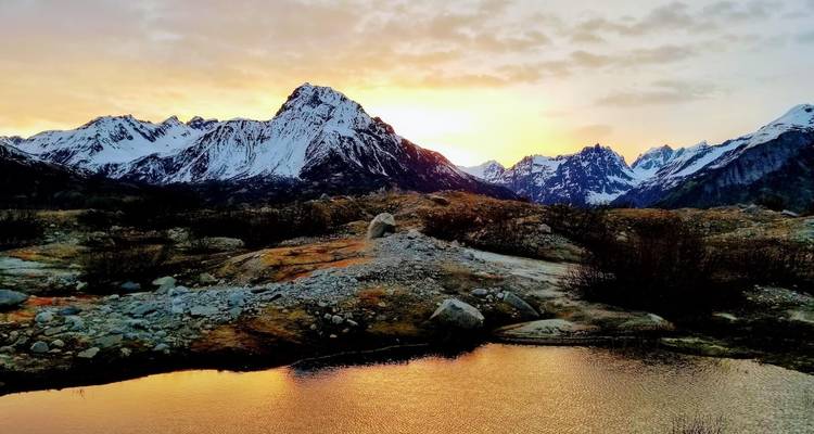 Beautiful sunset over snow-capped mountains and a reflective lake.