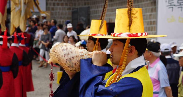 Desfile con personas vestidas con traje tradicional coreano y vestimenta colorida.