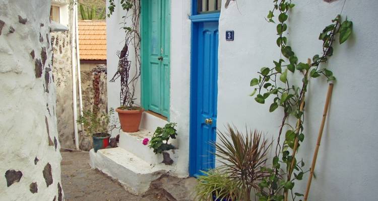 Calle con casas blancas que tienen puertas azules.