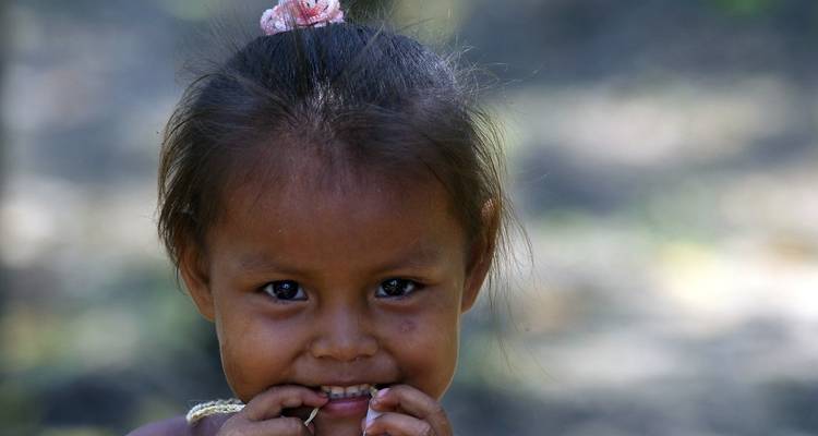 Une jeune fille avec une expression curieuse à l'extérieur.