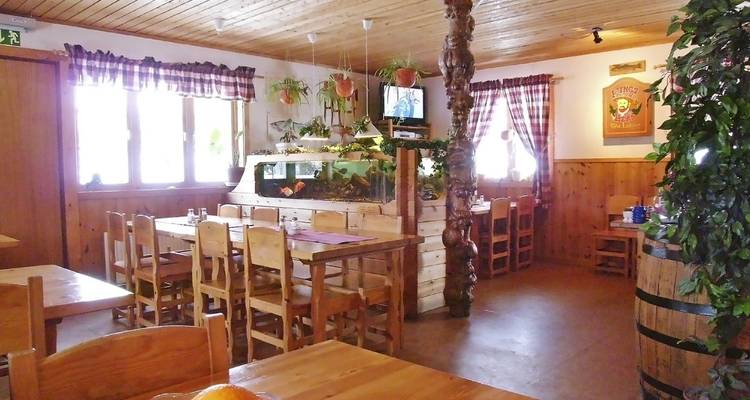 Inside a cozy, rustic restaurant with wooden furniture and decor.