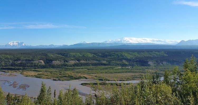 Scenic valley with a pristine river and snow-capped mountains.