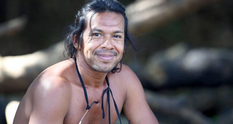 Portrait of a man smiling at the camera in a natural setting.
