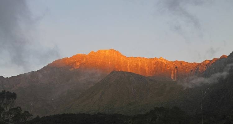 Bergspitze, die vom Sonnenaufgang beleuchtet wird.