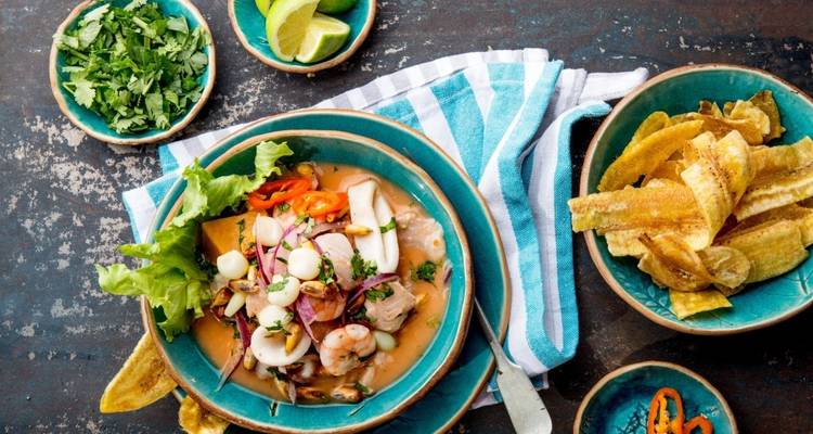Teller mit Ceviche, Kochbananen-Chips und grüner Garnitur.