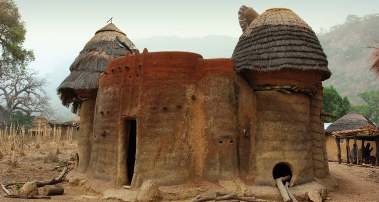 Bâtiment traditionnel en briques de terre crue avec toit de chaume.
