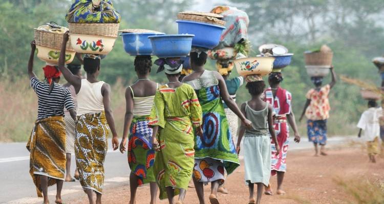 Groupe de femmes portant des paniers sur la tête.