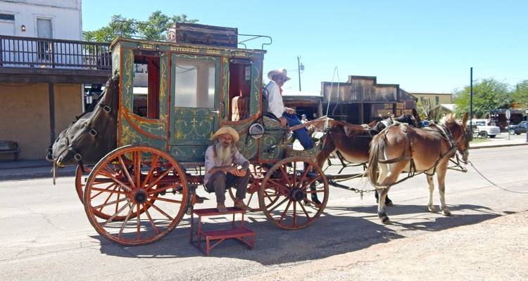 Vintage paard-en-wagen met mensen aan boord in een rustieke omgeving.