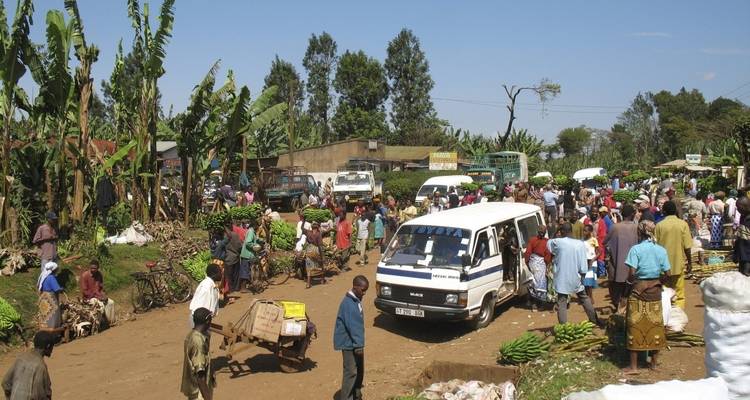 A busy local market scene with people and vehicles.