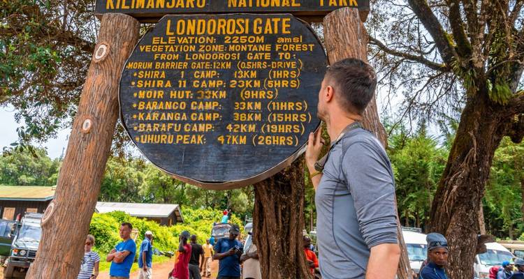 Person examining a signboard at Kilimanjaro National Park.