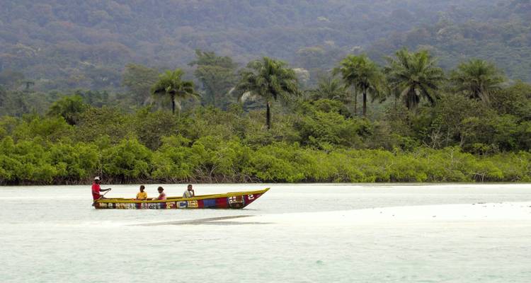 Menschen in einem kleinen Boot navigieren einen ruhigen Fluss.