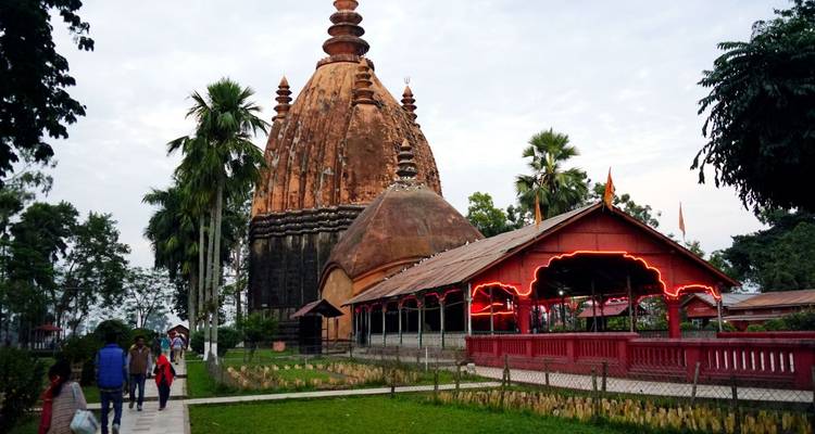 Traditioneller Tempel mit beleuchteten Wegen und Menschen, die umhergehen.