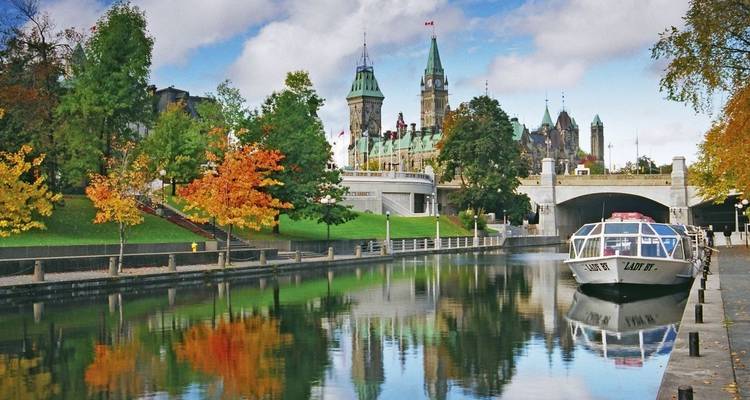 Canal pintoresco con edificios históricos y follaje otoñal.