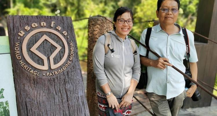 Deux touristes debout à côté d'un panneau du Patrimoine mondial.