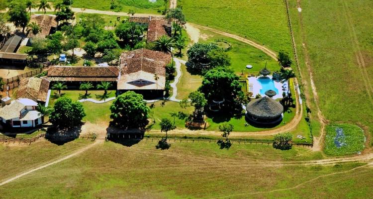 Vista aérea de un resort con piscina en un entorno rural.
