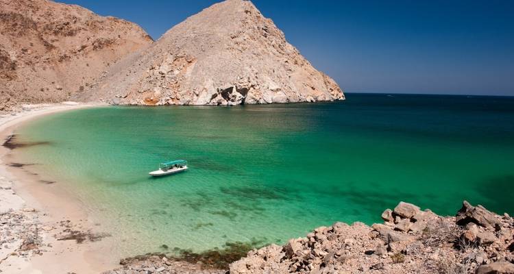 A serene beach with turquoise waters and a boat.