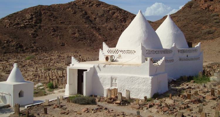 A white historic structure in a desert landscape.