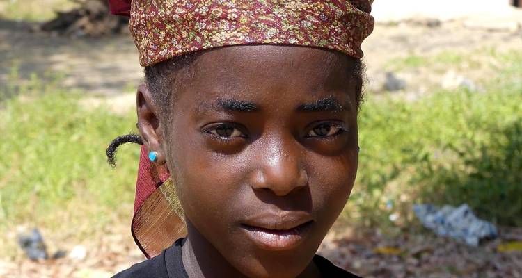 Young person wearing a headscarf looking at the camera.