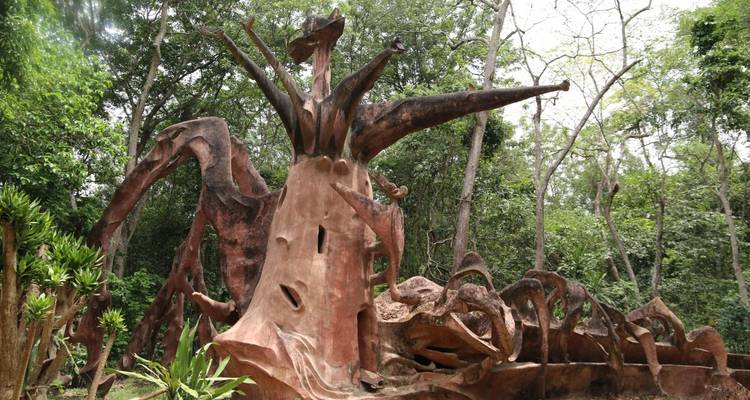 Scenic view of a large artistic wooden sculpture among trees.