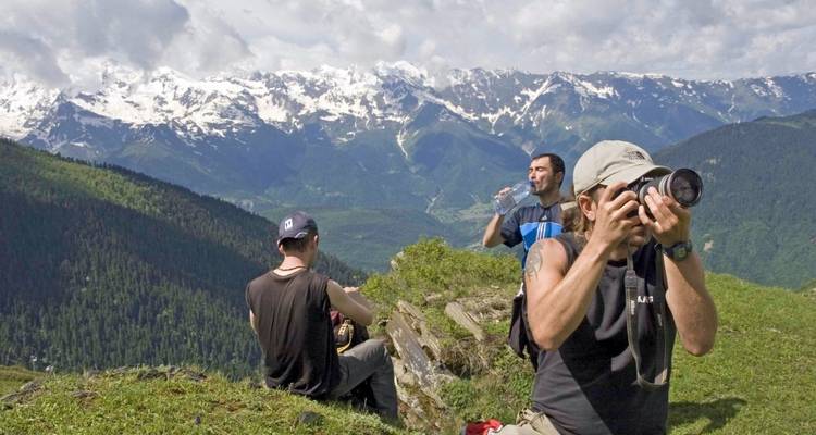 Turistas disfrutando de una vista de montaña con picos nevados.