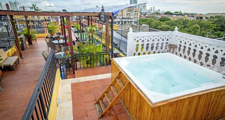 Eine Dachterrasse mit einem Whirlpool mit Blick auf eine Stadtlandschaft.
