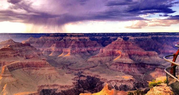 Vast panoramic view of the Grand Canyon under dramatic skies.