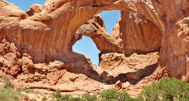Natural rock arch formations in a desert landscape.