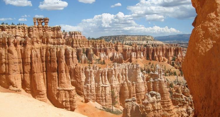 Row of unique rock formations under a bright blue sky.