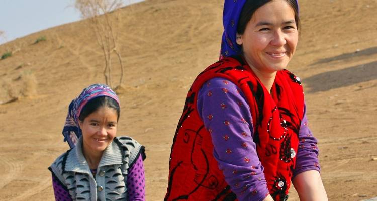 Deux jeunes filles en vêtements colorés à l'extérieur souriantes.