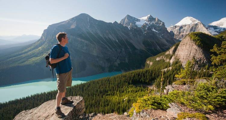 Randonneur contemplant un paysage montagneux époustouflant avec des lacs.