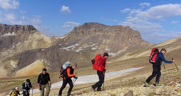Hikers trekking uphill on a rocky terrain.