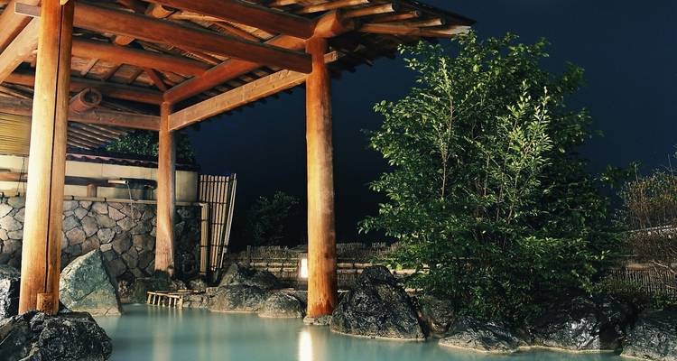 Onsen japonais avec une source chaude naturelle extérieure et une structure en bois.