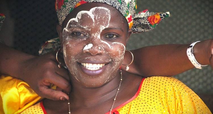 Woman with traditional face paint smiling warmly.