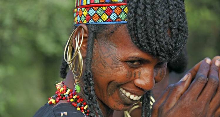 Smiling woman with traditional tattoos and jewelry.