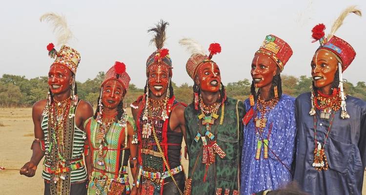 Group of people in traditional attire with face paint.