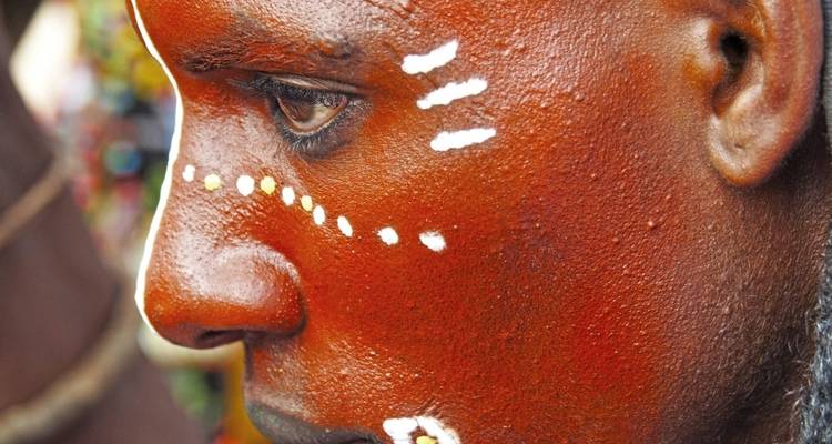 Close-up of face with traditional face paint and beads.