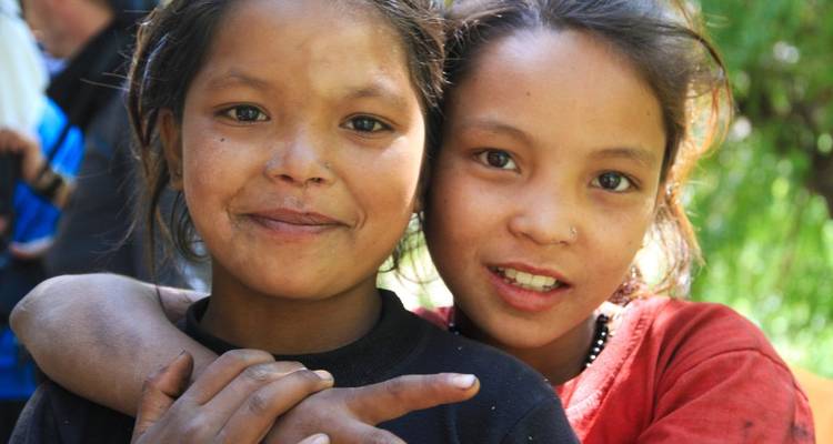 Twee kinderen die naar de camera glimlachen.