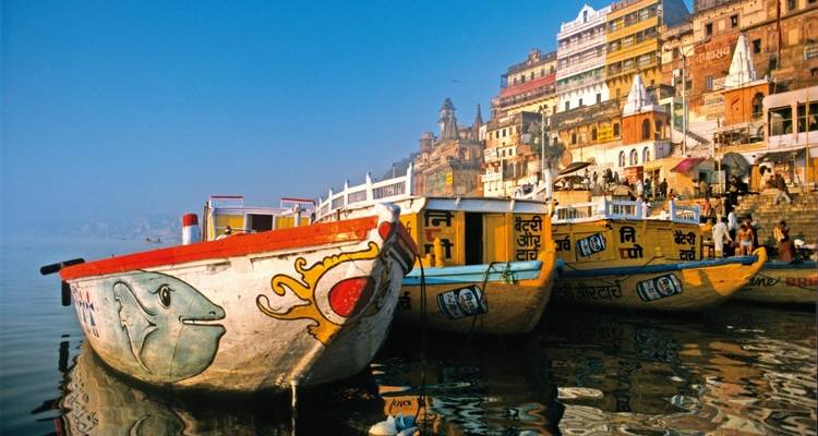 Bunte Boote auf dem Fluss mit Gebäuden am Flussufer.
