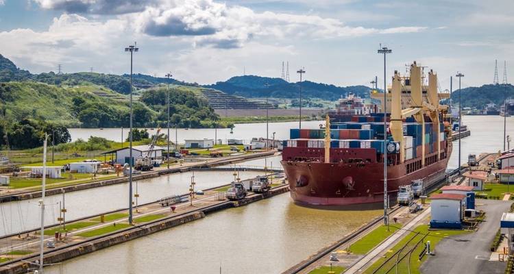 Large container ship navigating a canal lock.