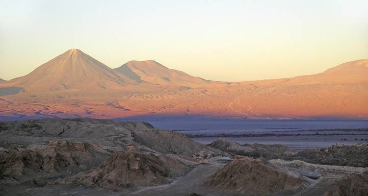 Amplio paisaje desértico con montañas distantes al atardecer.