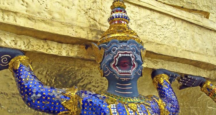 Decorative statues on a golden temple wall.