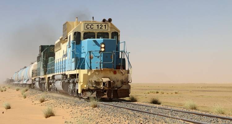 Freight train traveling through a desert landscape.